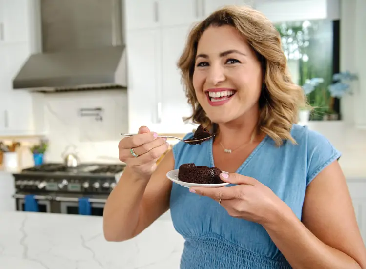 Benita smiling and eating chocolate cake